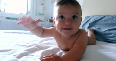 Sevimli bebek yatakta mutlu yatıyor.