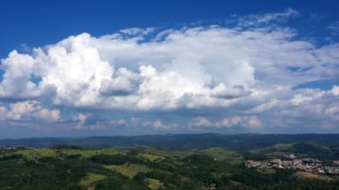 Clouds in timelapse motion in countryside landscape, aerial drone view