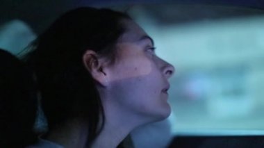 Woman driving in city at night. profile of female driver in the evening
