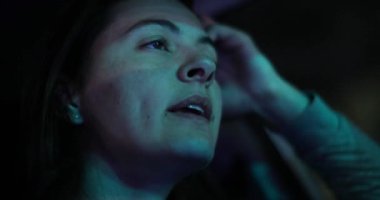 Woman driving at night in city. Female driver face talking and driving
