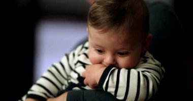 Geceleri pijama giyen sevimli bir bebek. Anne kucağında bebek var.