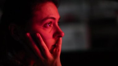 Woman driving stopping in red light in city at night