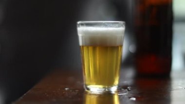 Hand picks glass beer close-up