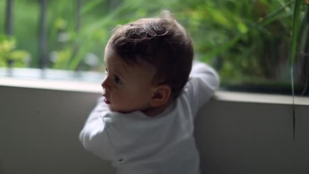 Дитячий Хлопчик Стоїть Біля Вікна Вдома Однорічний Малюк Повертає Голову — стокове відео