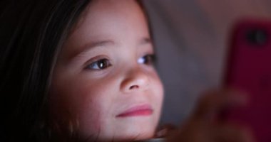 Child girl turning cellphone flashlight ON