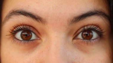 Macro close-up eyes and face looking to camera, woman shock with eyes wide open