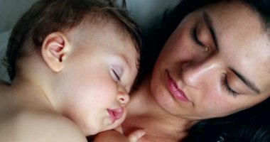 Baby and mother faces sleeping napping