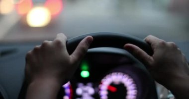 Female hands holding steering wheel POV driving in urban city point of view