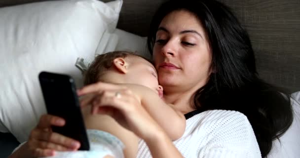 Mother Using Cellphone Device Home Lying Bed Sleeping Baby Chest — Video