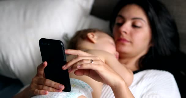 Candid Mother Looking Smartphone While Baby Infant Naps — Video