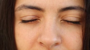 Woman opening eyes looking to camera, macro close-up female eye staring to lens