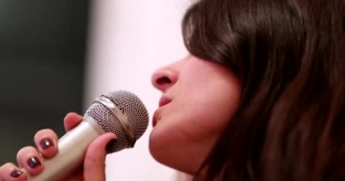 Woman singing karaoke holding microphone