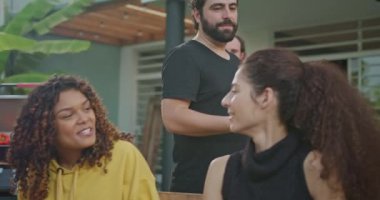 Barbekü partisinde bir grup mutlu arkadaş. Barbekü şefi arkadaşlarına ve ailesine yemek servisi yapıyor. Gülen ve gülümseyen insanlar.