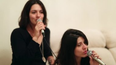 Women singing karaoke, casual girls holding microphone sing lyrics