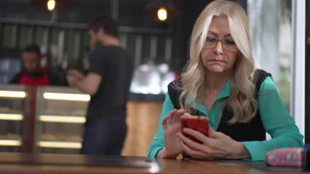 Senior Vrouwelijke Uitvoerende Vrouw Met Behulp Van Smartphone Coffeeshop Onbeslist — Stockvideo