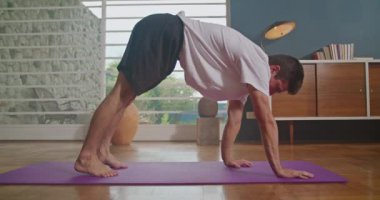Person practicing yoga at home. Man stretching body exercising in living room interior
