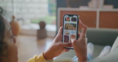 Yakın plan kadın elleri cep telefonlarını tutuyor internette yemek menülerini karıştırıyor. Uygulama aygıtında yiyecek siparişi arayan kişi