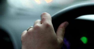 Hand holding steering wheel driving close-up