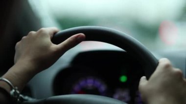 Woman hands holding steering wheel stuck in traffic