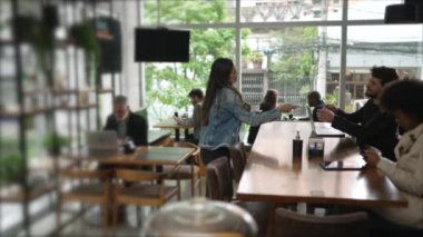 Kahve dükkanındaki müşteriler. Kafe restoranının içindeki erkek arkadaşına ekspreso getiren bir bayan arkadaş.