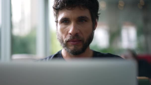 男人凝视着咖啡店旁边的笔记本电脑屏幕 在网上浏览有严肃表情的电脑的人 — 图库视频影像