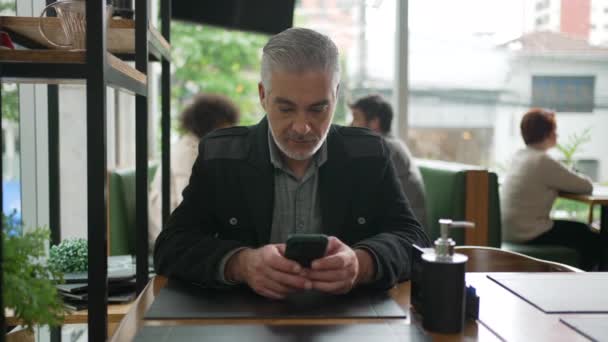 Hombre Mayor Utilizando Teléfono Celular Dentro Cafetería Viendo Contenido Línea — Vídeo de stock