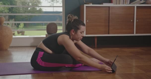 Athlete Trains Yoga Online Tablet Sitting Mat Pulls Leg Forward — Vídeo de Stock