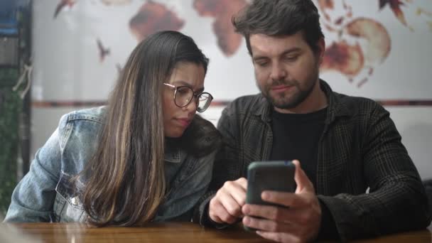 Casal Olhando Para Tela Smartphone Sentado Café Pessoas Rindo Sorrindo — Vídeo de Stock