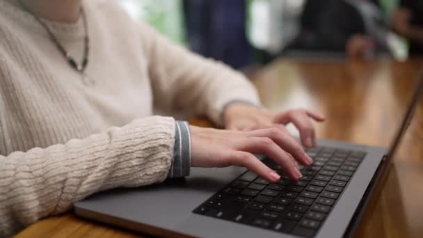 1人の若い女性がコーヒー店でリモートで働くノートパソコンのキーボードを入力します 喫茶店で電子計算機を使用する者 — ストック動画