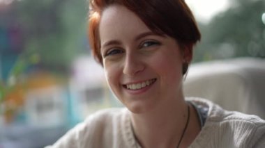 Kameraya gülümseyen kızıl saçlı genç bir kadının portresi. Mutlu 20 kız yüzü