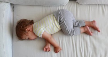 Baby napping in afternoon. From above angle of infant one year old toddler boy sleeping