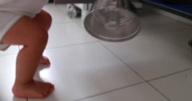 Baby toddler playing with kitchen utensils pans and pots, one year old kid covering camera