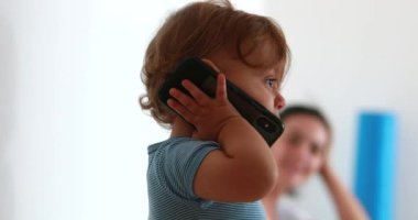 Baby talking on phone, infant with cellphone in ear, toddler giving smartphone to mom