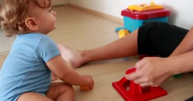 One year old infant baby boy throwing object away, child playing indoors during quarantine