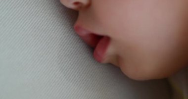 Infant baby drooling while napping, macro close-up of baby dribble drool