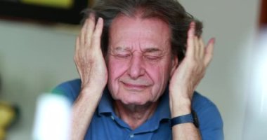 Senior man covering face with hands, older retired man rubbing face portrait