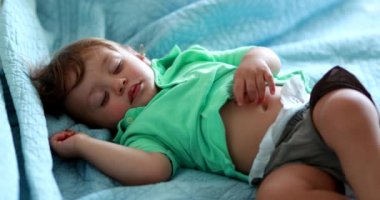 Adorable baby lying down in bed in afternoon nap sleeping