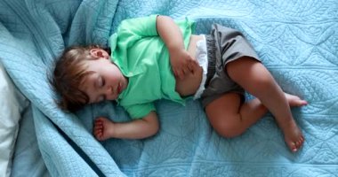 Baby boy lying in bed sleeping. One year old infant child asleep