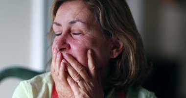 Stressed out older woman in 60s covering face with hands. Anxious worried senior woman feeling anxiety