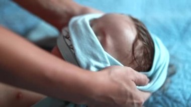 Parent putting shirt over one year old baby heat. Changing toddler clothes