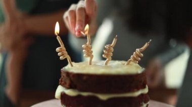 Doğum günü pastası mumlarını yakan eller. Yakından kutlama için el feneri yakan kişi.