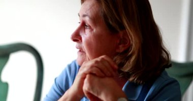 Candid pensive older woman in conversation. Senior retired lady chatting