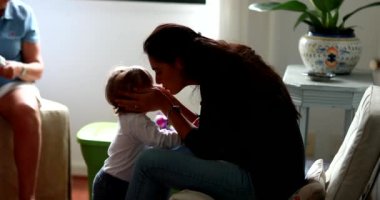 Candid mother kissing baby toddler. mom kisses child authentic love and affection