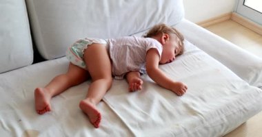 Cute baby sleeping on couch. Adorable infant child asleep napping