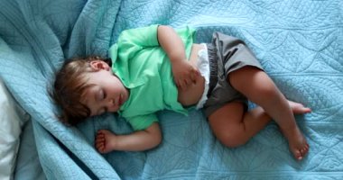 Cute baby boy asleep in bed. One year old child infant asleep napping