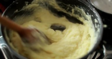 Stirring mashed potato inside pan