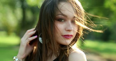 Mutlu, İspanyol asıllı, genç, yirmili yaşlarda, açık hava parkında gülümseyen bir kadın.