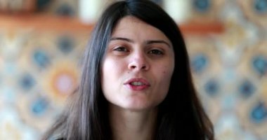 Portrait of attractive 30 year old woman talking to camera