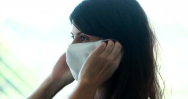 Woman putting pandemic face mask on face. Person wearing virus prevention surgical mask