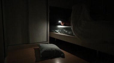Woman flashing light looking inside closet in the middle of the night